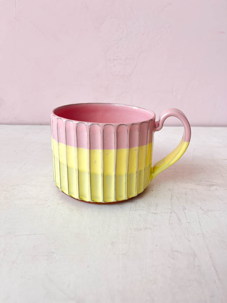 eine Tasse mit einem Griff aus Trine Lise Keramik, gelb und rosa