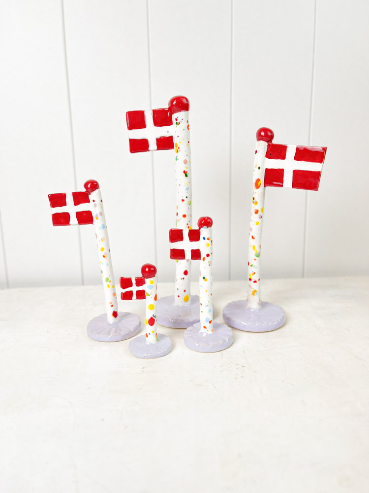Handgemachte Keramik-Flagge aus dem Tonspiel in Harlekin-Flagge mit lila Fuß