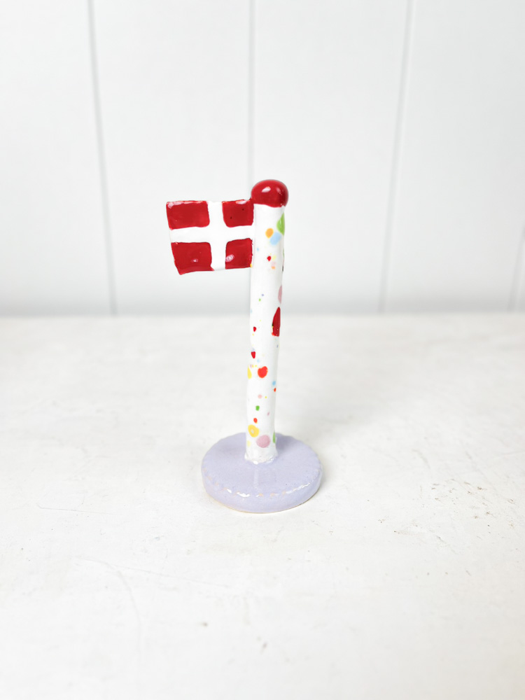Handgemachte Keramik-Flagge aus dem Tonspiel in Harlekin-Flagge mit lila Fuß