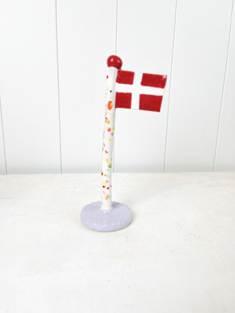 Handgemachte Keramik-Flagge aus dem Tonspiel in Harlekin-Flagge mit lila Fuß