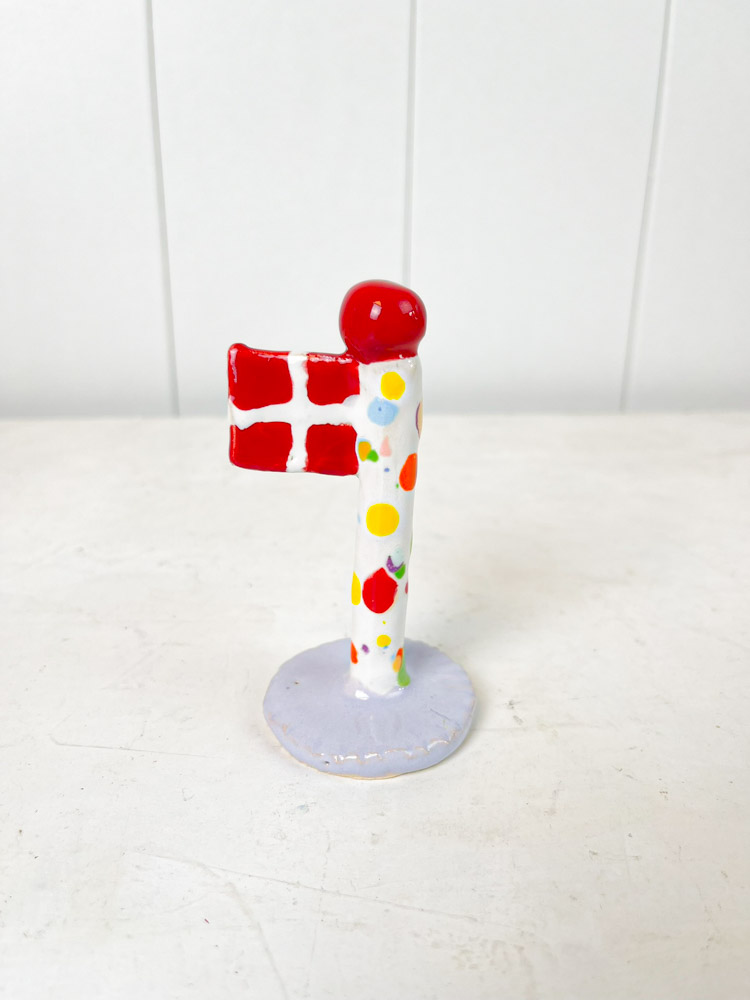 Handgemachte Keramik-Flagge aus dem Tonspiel in Harlekin-Flagge mit lila Fuß